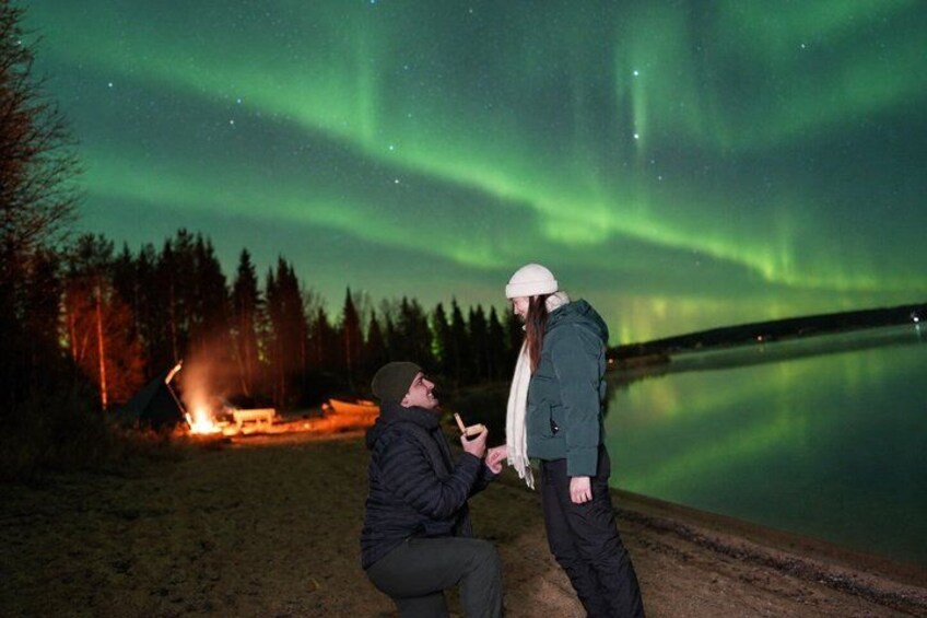 Two people by a lakeside at night with the aurora borealis in the sky. 3