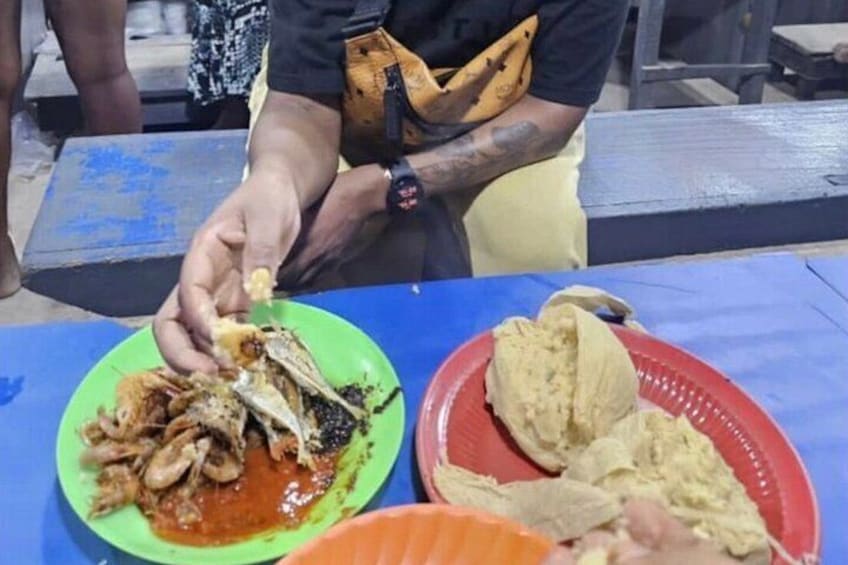 A person serving food from a green plate with a red sauce, a red plate with a white substance, and a red plate with a yellowish substance. 5