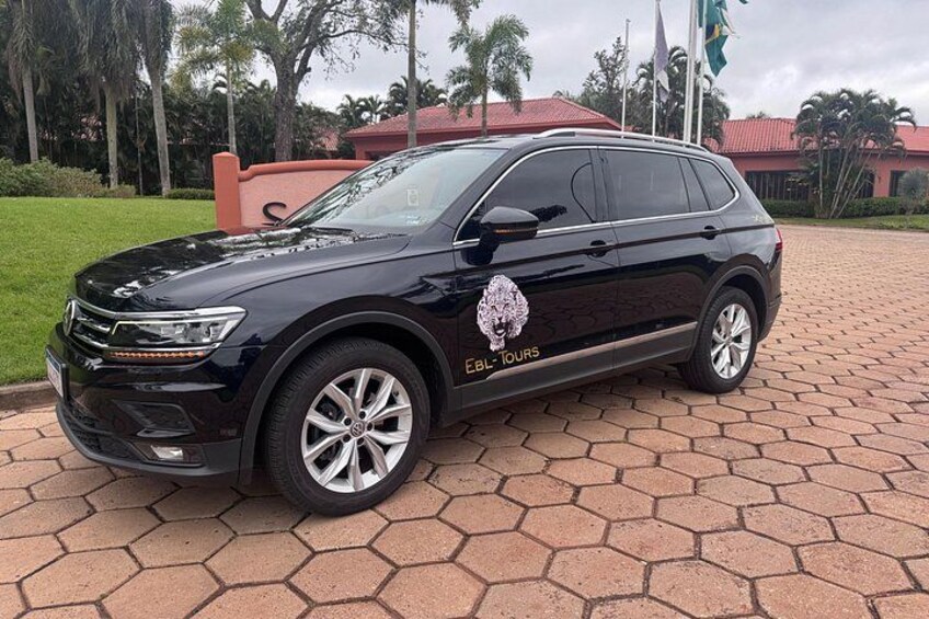 Un SUV negro estacionado en un área pavimentada con un logotipo en su lateral. 2