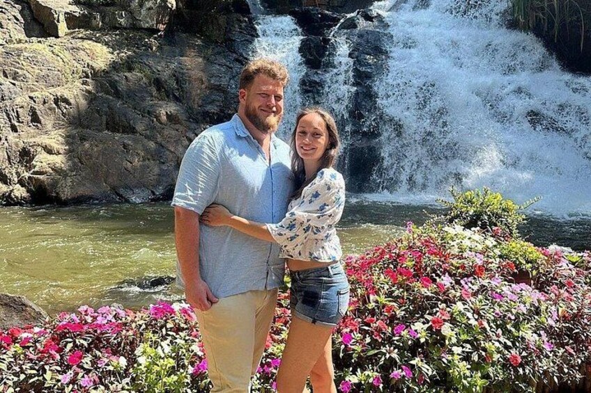 A waterfall, a couple, and colorful flowers. 1