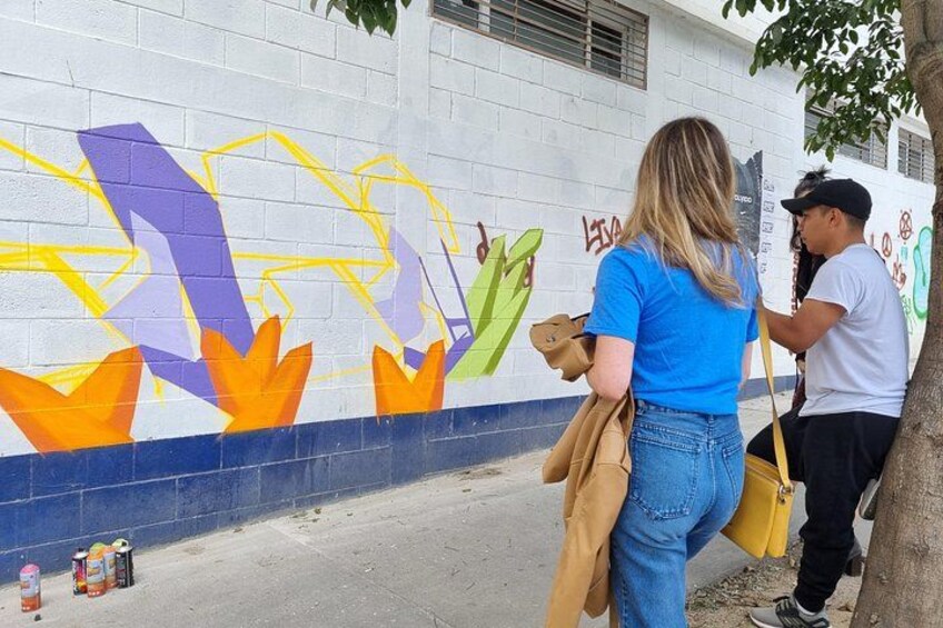 Une personne est en train de peindre une fresque colorée sur un mur. 3