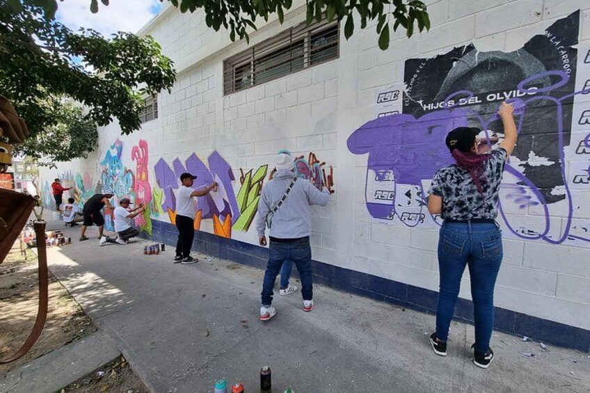 Des personnes peignent une fresque sur un mur. 2