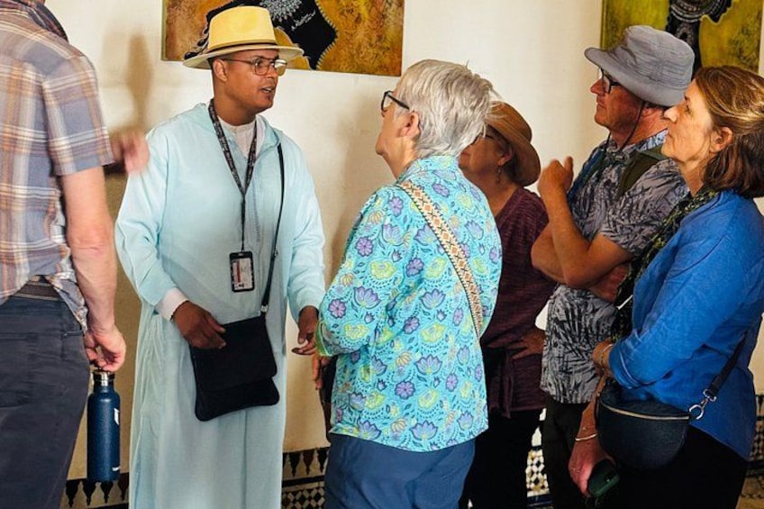 A group of people in a room with a patterned wall and a blue water bottle. 3
