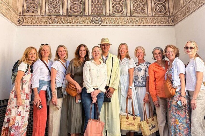 A group of people standing in front of a building with intricate architectural details. 1