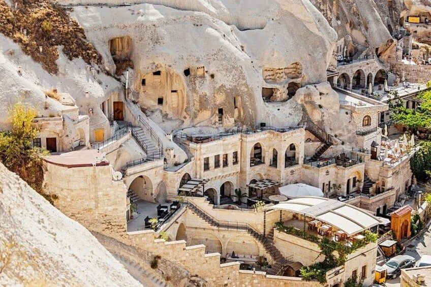 A mountainous village with traditional architecture carved into the rock, featuring narrow streets and stone buildings. 2