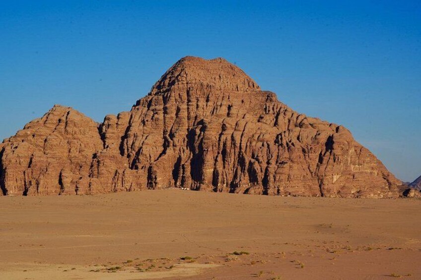 Una montaña imponente y escarpada en un paisaje desértico. 5