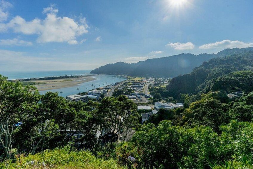 A coastal town with buildings, a beach, and a mountainous backdrop. 1