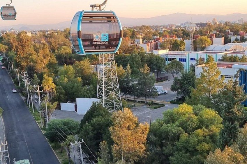 Un sistema de teleférico, una carretera y un paisaje urbano con edificios y árboles. 1