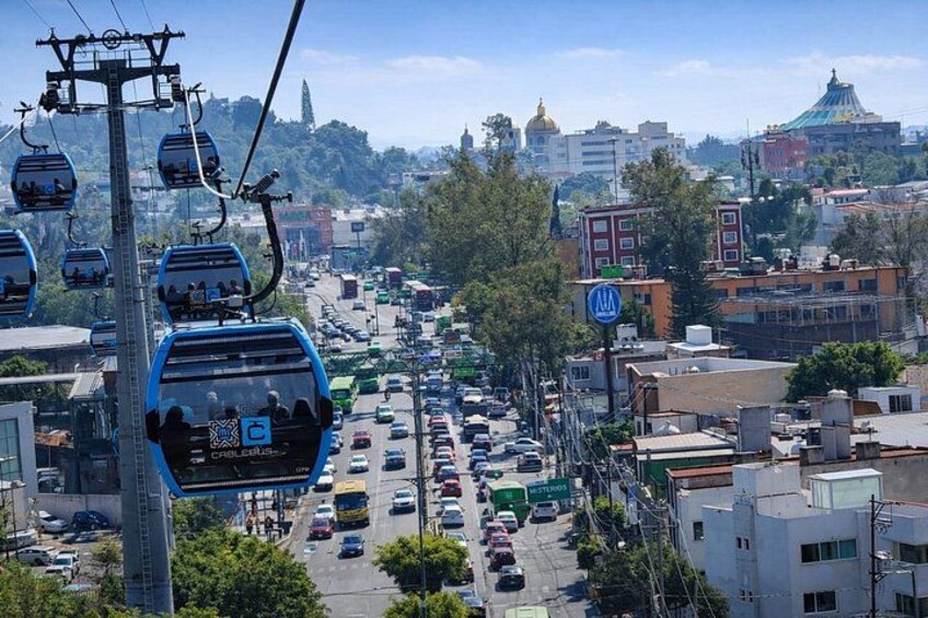 Un sistema de teleférico, una calle concurrida y edificios urbanos. 3
