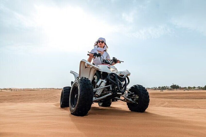 A person riding a quad bike on a sandy terrain. 5
