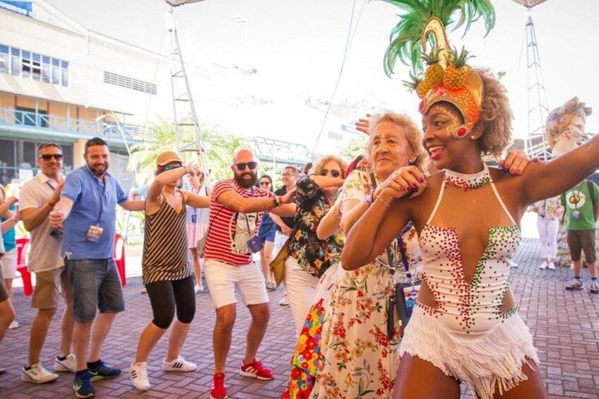 A group of people dancing outdoors, some in casual clothing and others in costumes. 4
