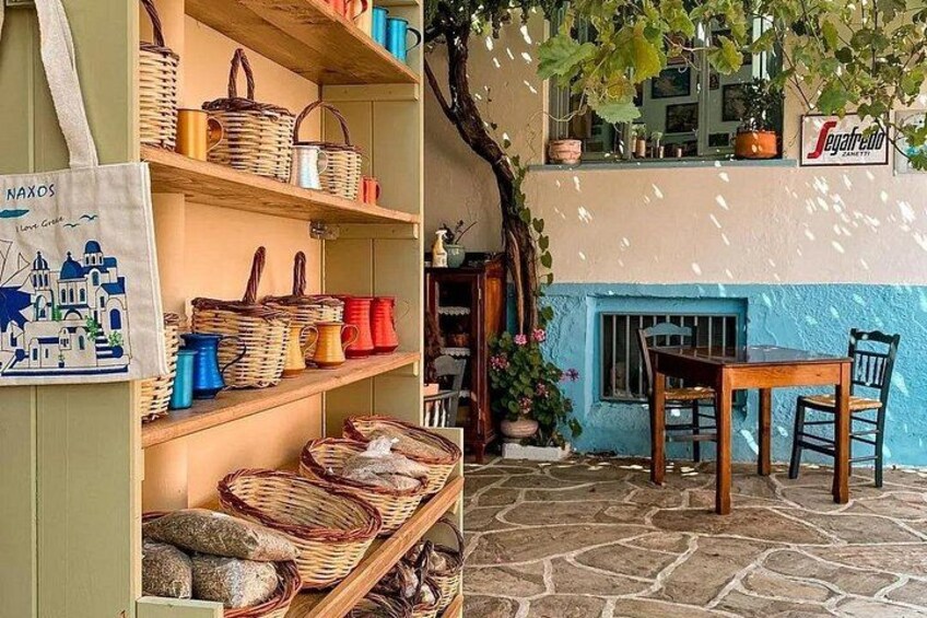 Un décor extérieur rustique agrémenté de paniers en osier, d’une table en bois et d’un mur aux couleurs bleu et blanc. 3