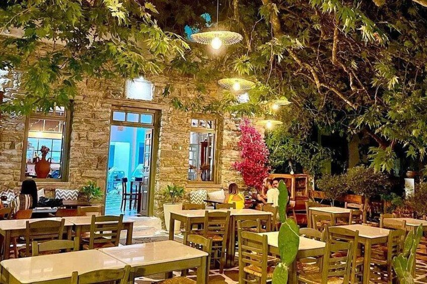 Un espace de restauration intérieur avec des murs en pierre, des tables en bois et des luminaires suspendus. 2
