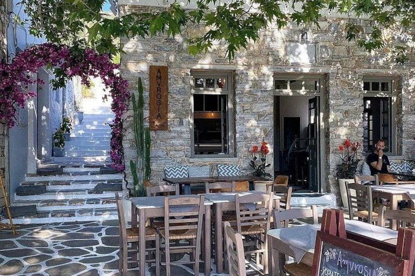 A stone building with outdoor seating, a staircase, and a sign reading 'AMYROSIA'. 5