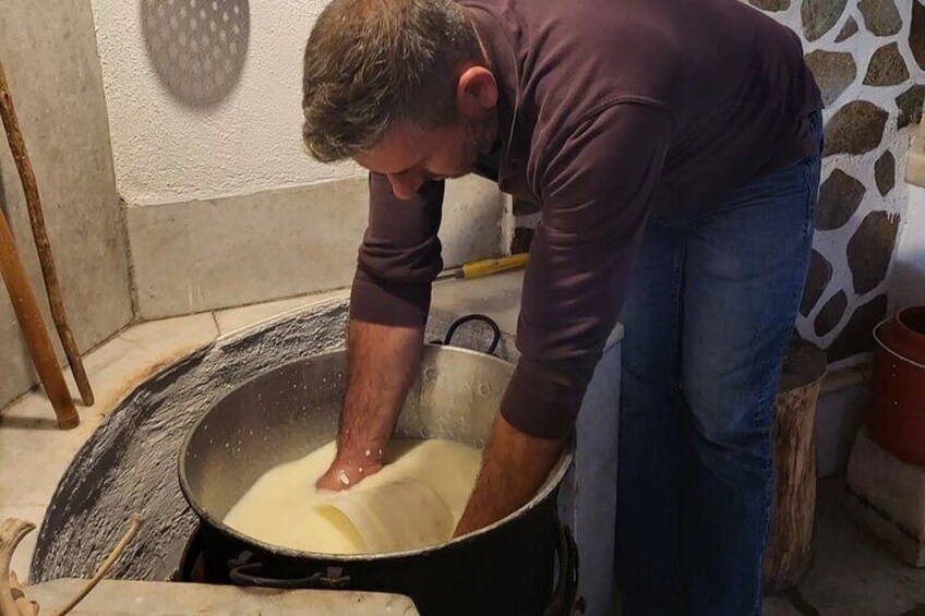 Iemand kneedt deeg in een grote, zwarte pan. 2