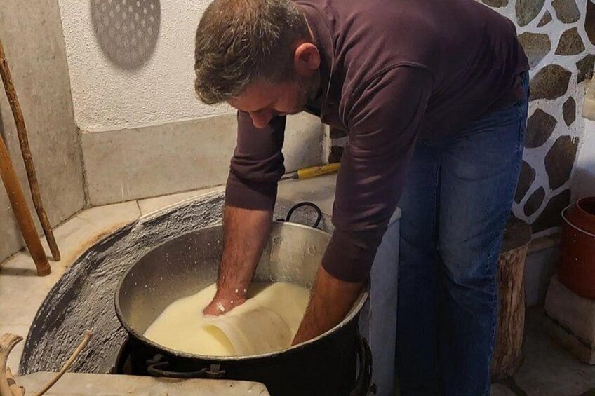 Una persona amasando masa en una olla negra grande. 2