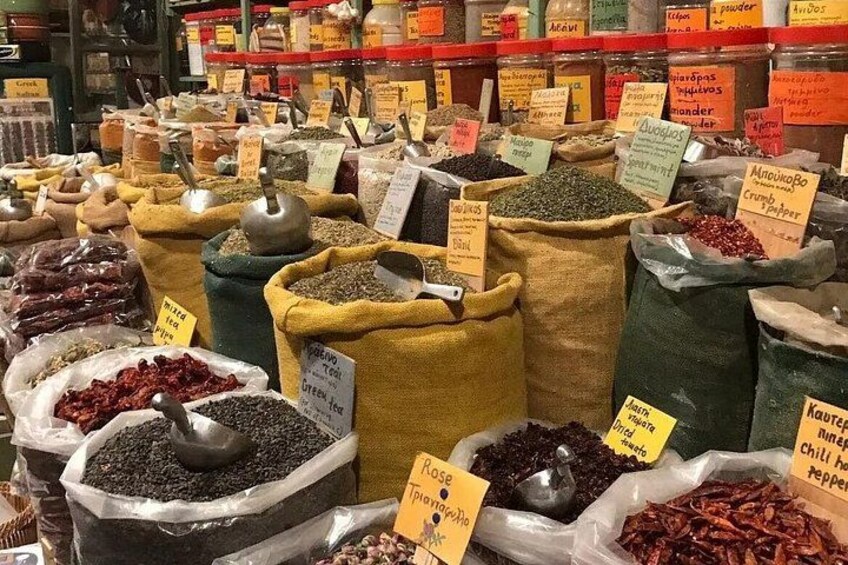A spice market with various sacks of spices and herbs, some with metal scoops. 4
