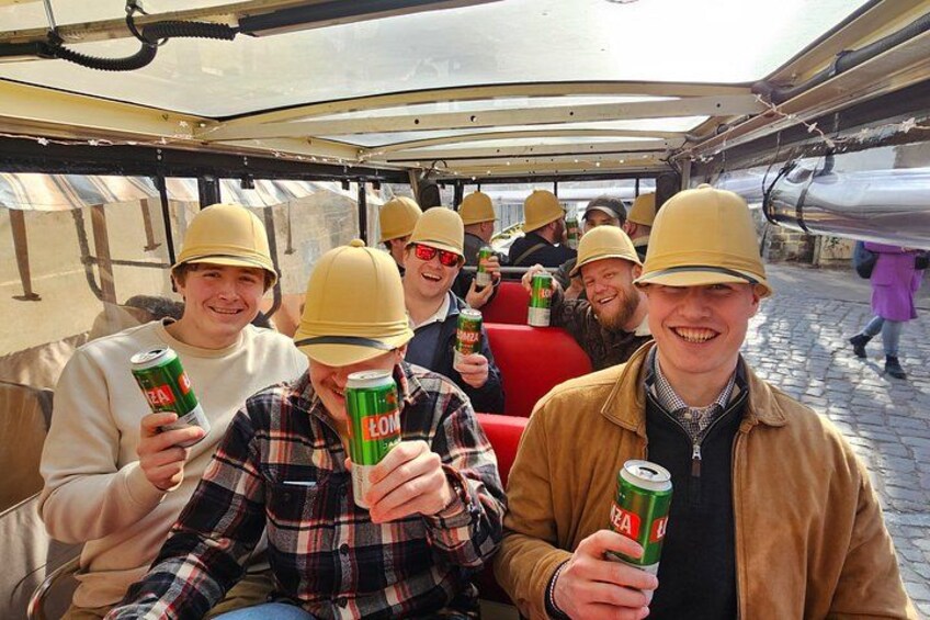 Persone su una barca, che tengono lattine di birra, con una struttura metallica sullo sfondo. 4