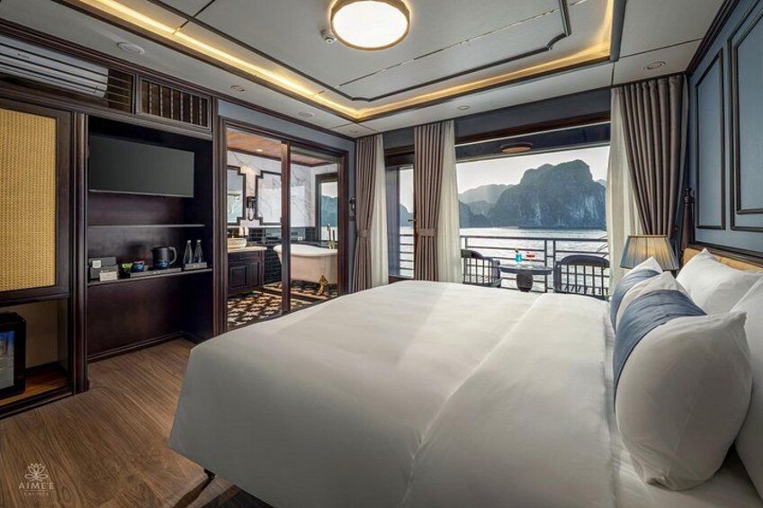 A luxurious bedroom with a large bed, a television, and a view of the sea. 3