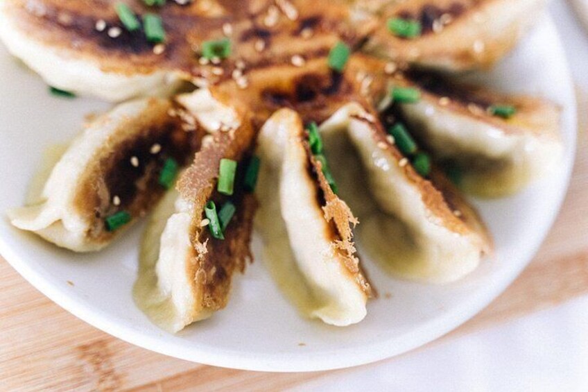 Un plato de dumplings decorado con semillas de sésamo y cebolletas picadas. 2