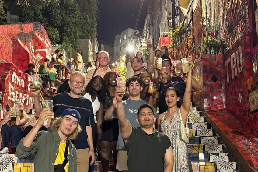 A group of people celebrating with drinks in a decorated urban setting. 1