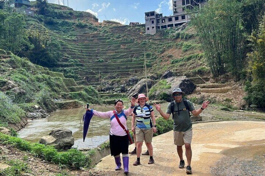 A group of people standing on a path with terraced fields in the background. 2