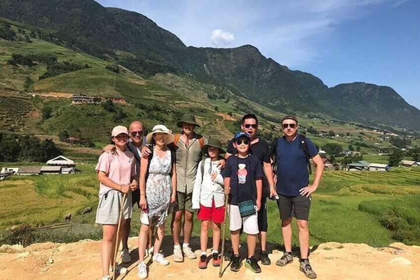 A group of people standing on a dirt path with a mountainous landscape in the background. 4