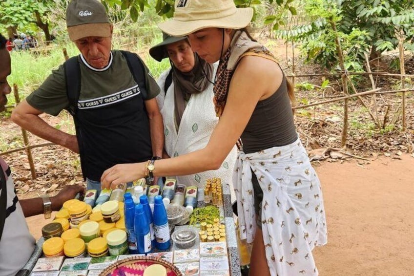 A person serving food at an outdoor market with a table full of various food items and condiments. 5