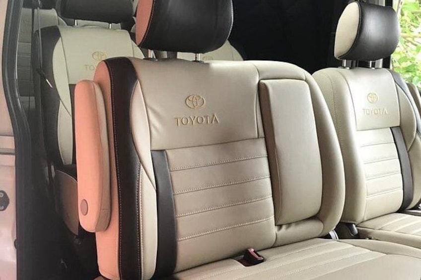En bilinredning med beige och svarta säten, ett synligt säkerhetsbälte och en Toyota-logotyp. 3