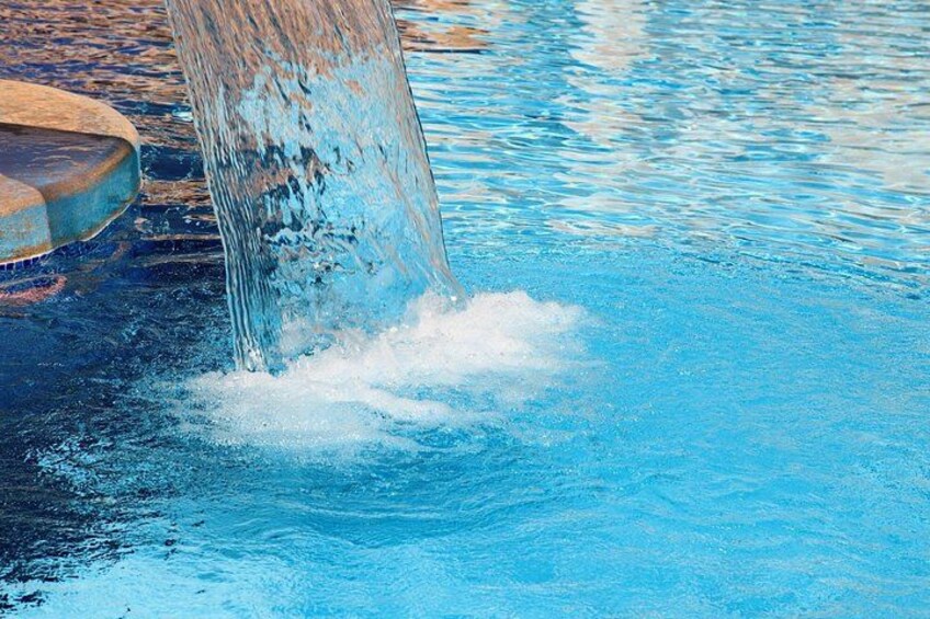 A pool with clear blue water and a visible water spout. 5