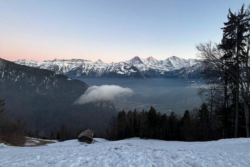 A snow-covered mountain landscape with a lake and forested area. 5