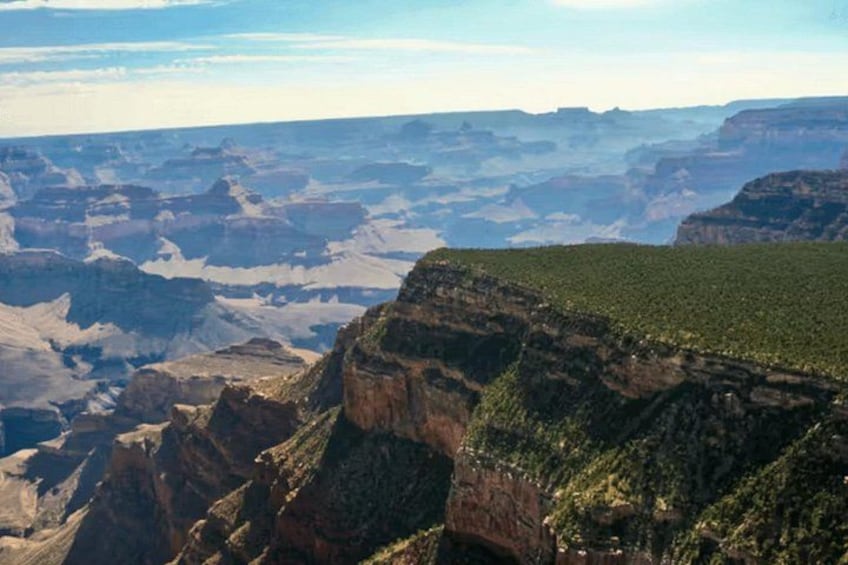 A canyon landscape with steep cliffs and sparse vegetation. 3