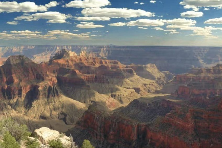 A vast canyon landscape with layered rock formations and a clear sky. 4