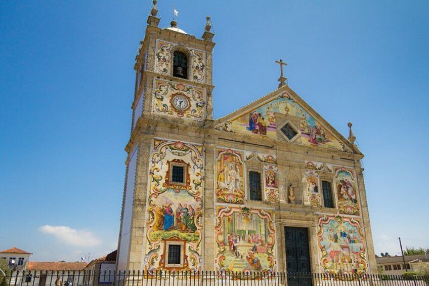 Une église dotée d’un clocher et ornée de fresques colorées. 3