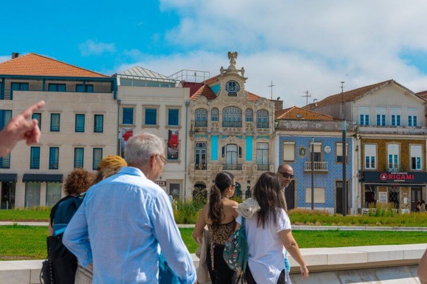 A group of people walking in a plaza with historic buildings in the background. 3