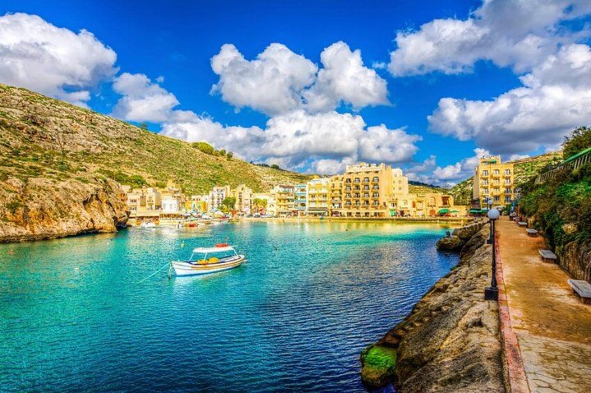 A coastal town with buildings, a boat, and a clear blue sky. 3