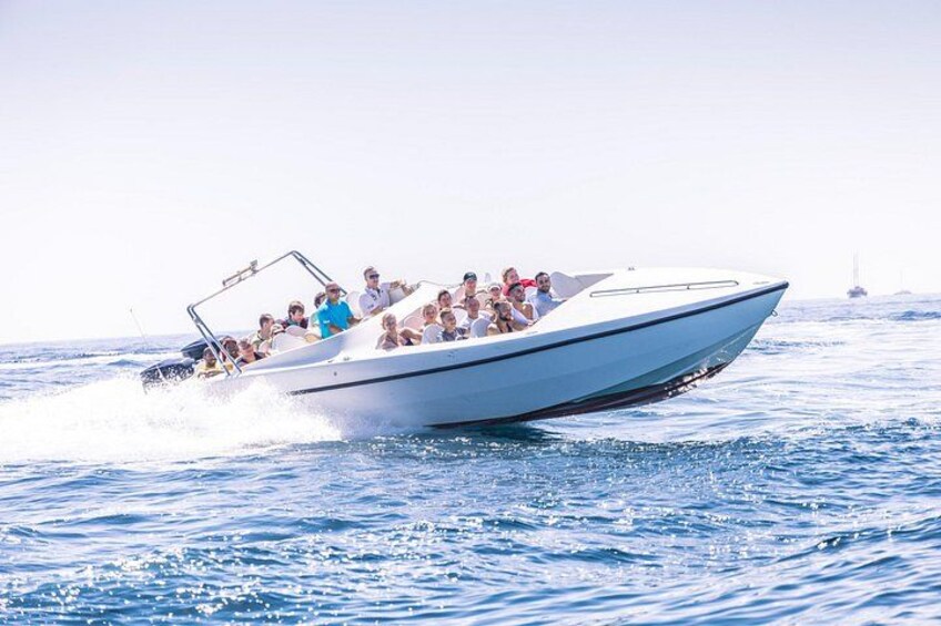 A speedboat with passengers on a clear day. 1