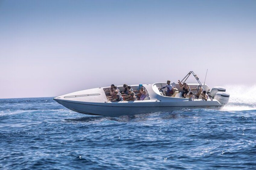 A speedboat with passengers on the water. 4
