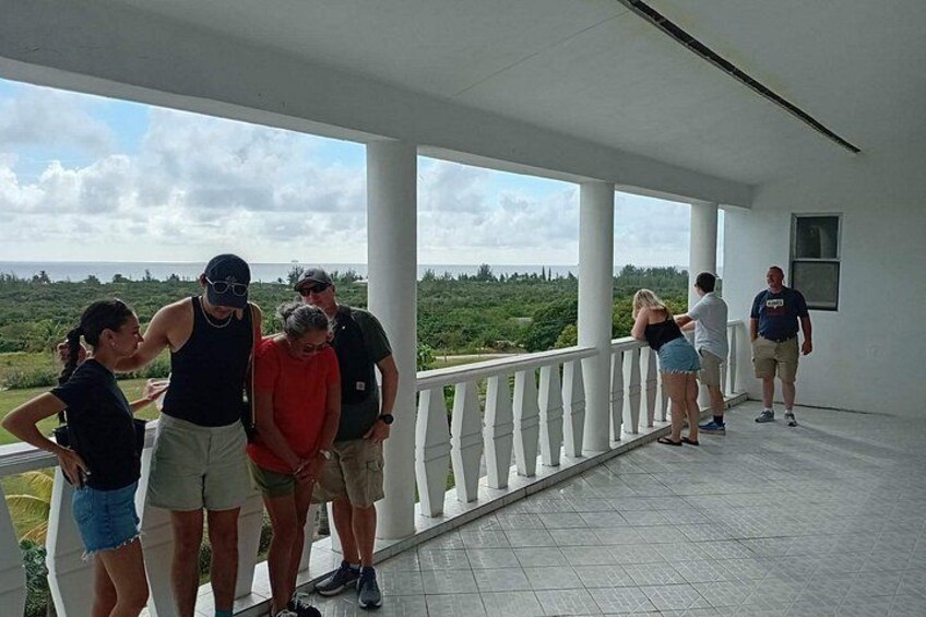 A group of people on a covered porch overlooking a landscape. 2
