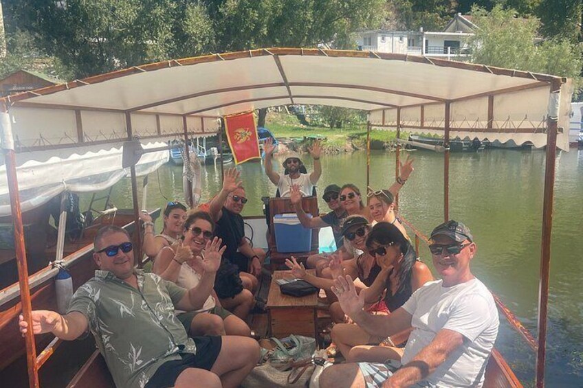 Un grupo de personas en un barco con toldo, saludando y sonriendo. 5