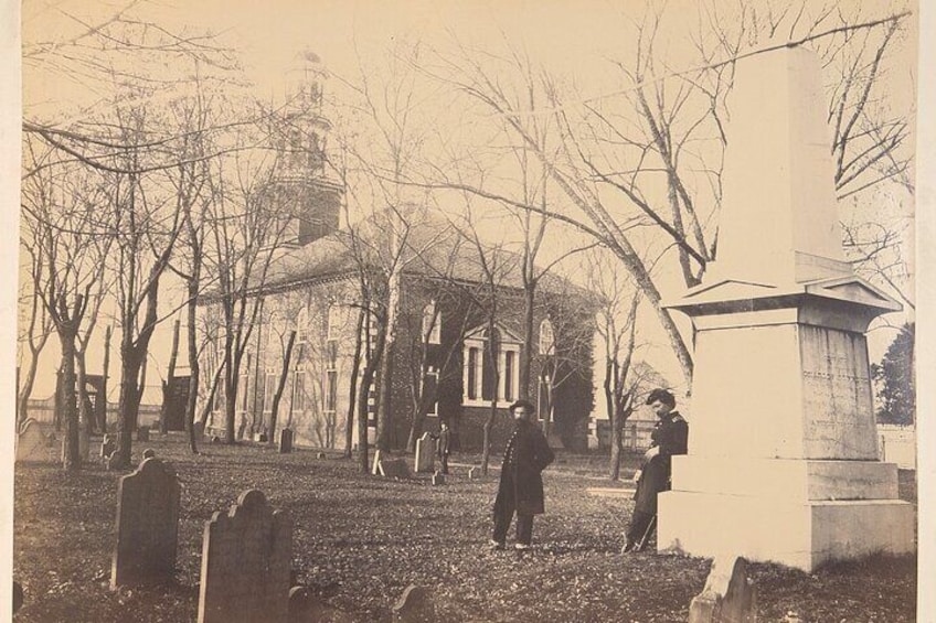 Un cimetière avec des pierres tombales, une église et un monument. 1