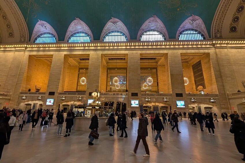A large indoor space with high ceilings, large windows, and a crowd of people. 1