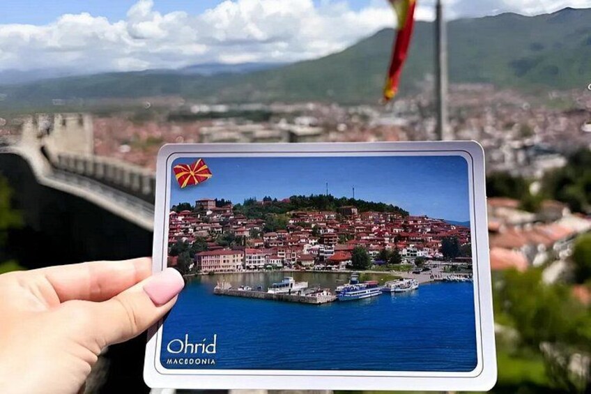 A tablet displaying a scenic view of Ohrid, Macedonia, with a bridge and a mountainous backdrop. 5