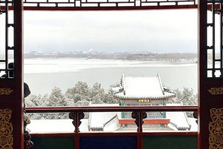 A traditional building with a snow-covered roof, a river in the background, and a distant cityscape. 2