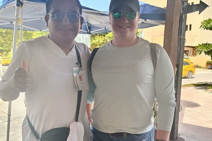 Two people standing under a tent, one giving a thumbs-up. 4