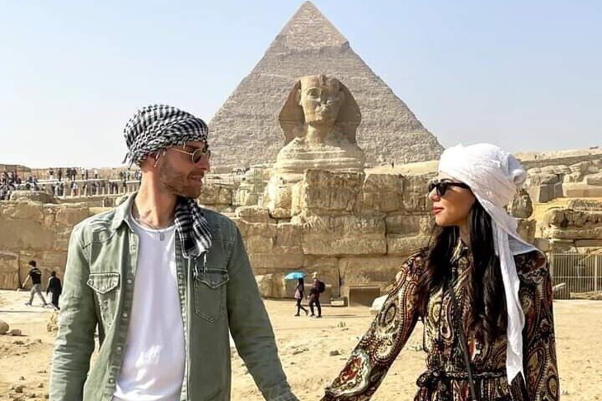 A man and a woman standing in front of the Great Pyramid of Giza. 3