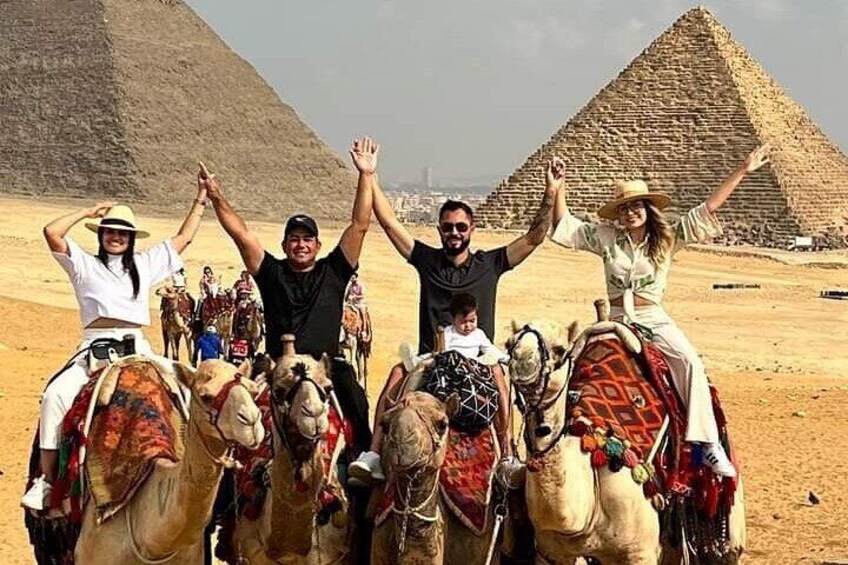 A group of people on camels in front of the Great Pyramid of Giza. 1