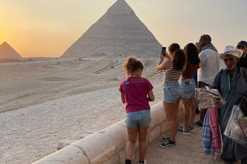 Tourists at the base of the Great Pyramid of Giza during sunset. 4