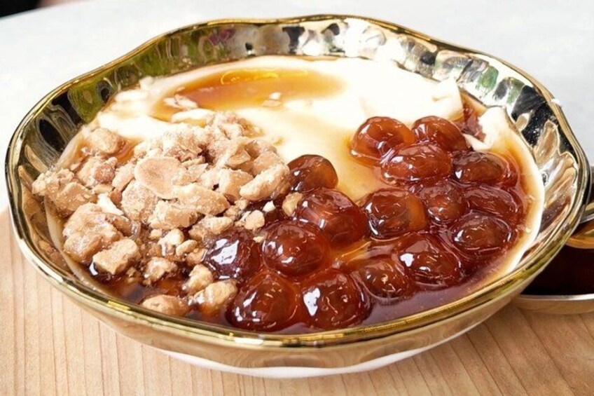 A dessert with a creamy topping, a syrupy sauce, and a fruit compote. 4
