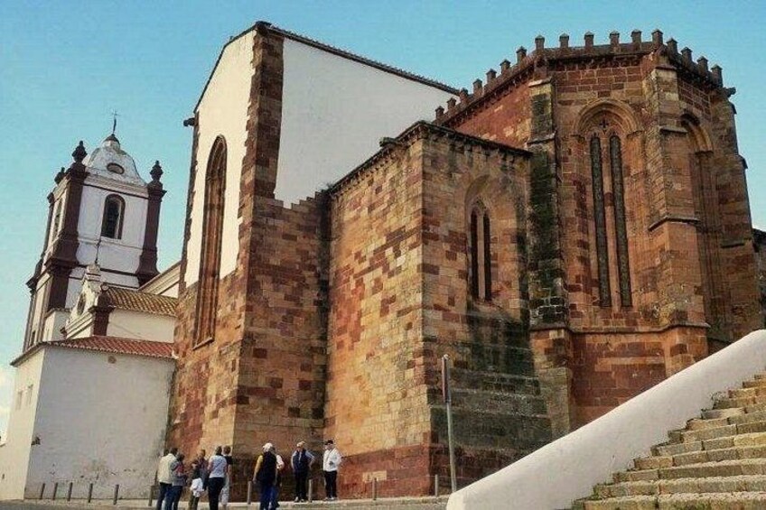 A historic church with a bell tower and a staircase leading up to it. 3